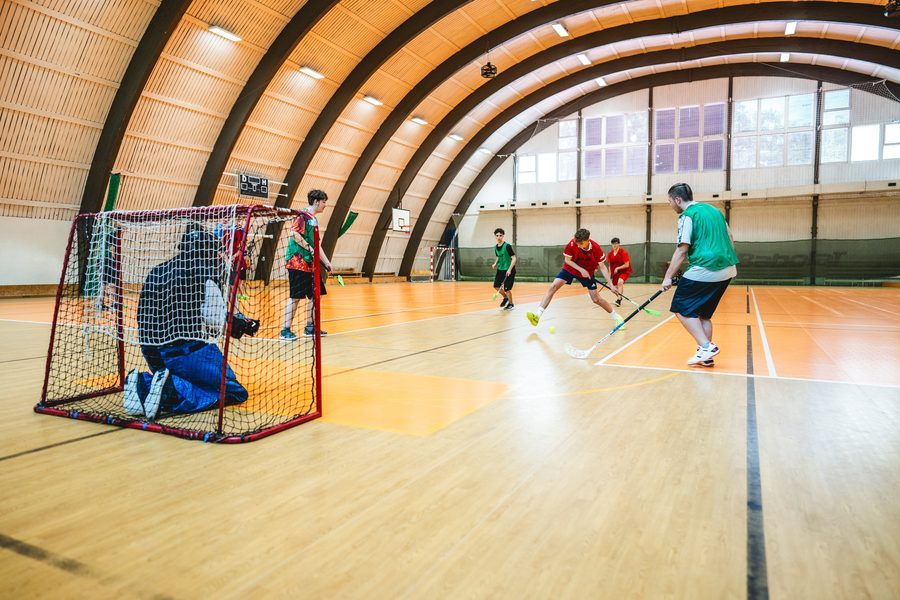 Žáci hrají florbal ve školní sportovní hale