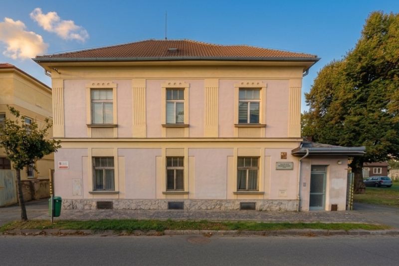 Budova v Benešově ulici — dvoupatrová vila se světle růžovou fasádou, vchod vpravo v přístavku